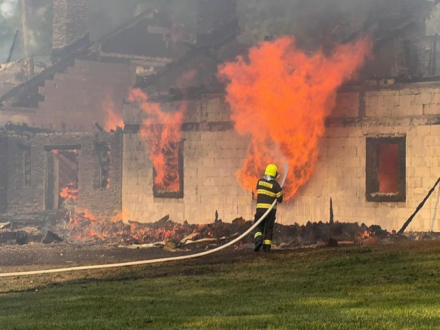 Hasič hasí požiar rekreačnej chaty.