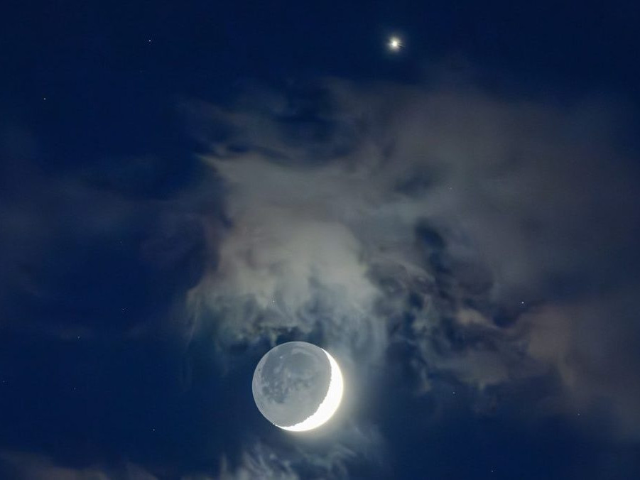 Mesiac s Venušou (v hornej časti obrázka) na podvečernej oblohe.