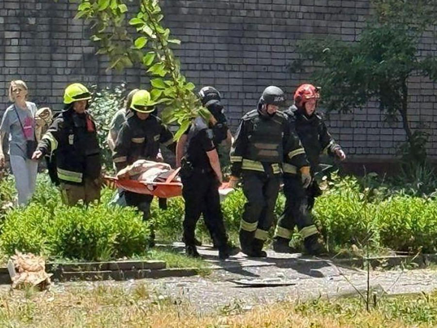 záchranári odnášajú zraneného muža po ruskom útoku