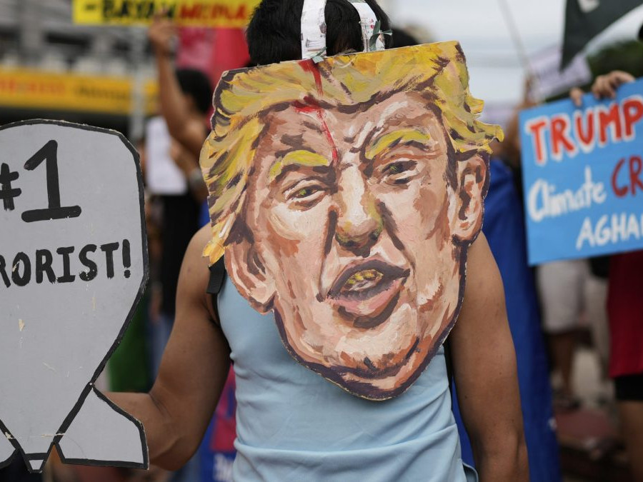 Protestujúci s portrétom amerického prezidenta Donalda Trumpa držia slogany, ktorými odsudzujú nedávne bombardovanie Iránu zo strany USA počas zhromaždenia v meste Quezon na Filipínach.