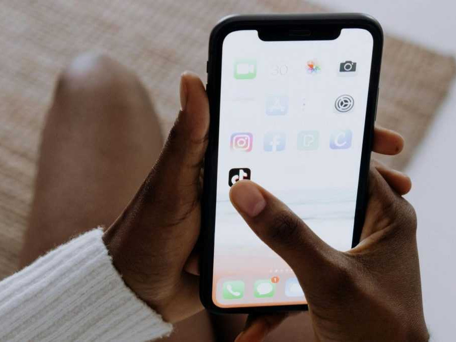 Na ilustračnej snímke žena na telefóne zapína aplikáciu TikTok.