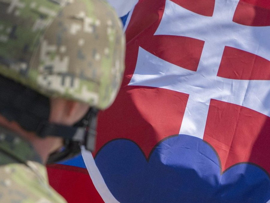 Vojak pred slovenskou vlajkou.