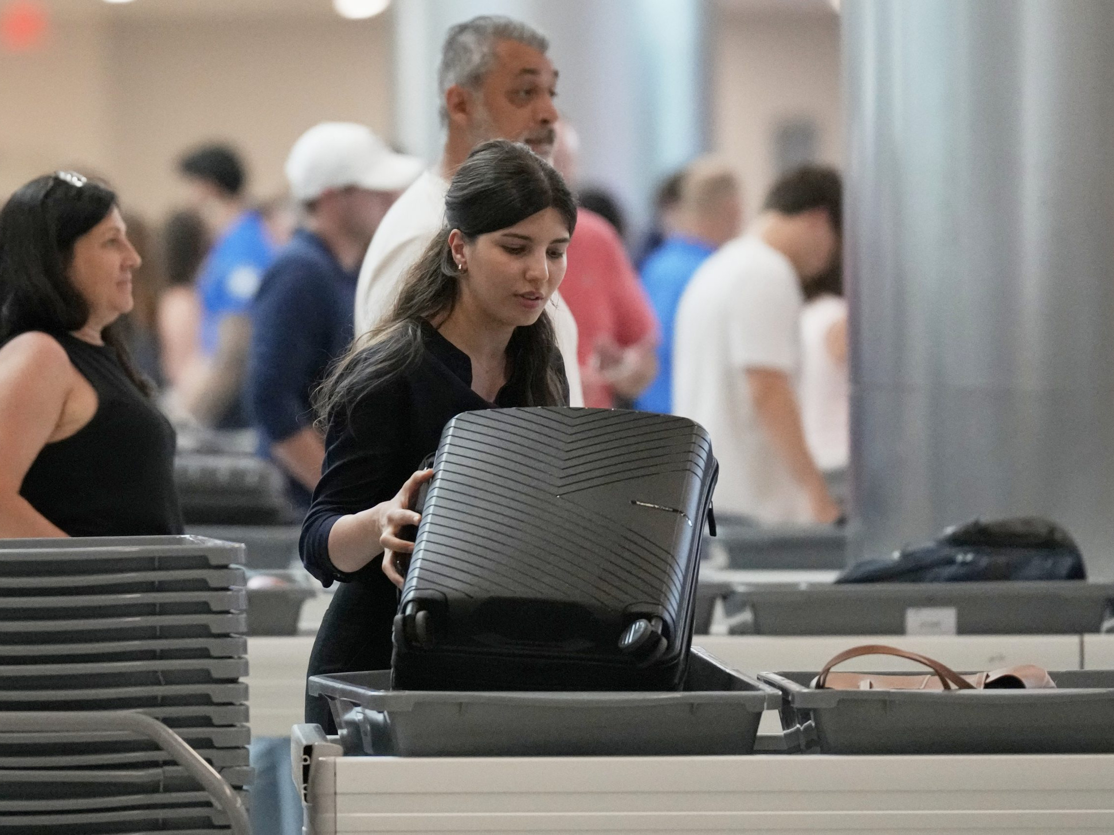 Na snímke žena počas kontroly batožiny na letisku.