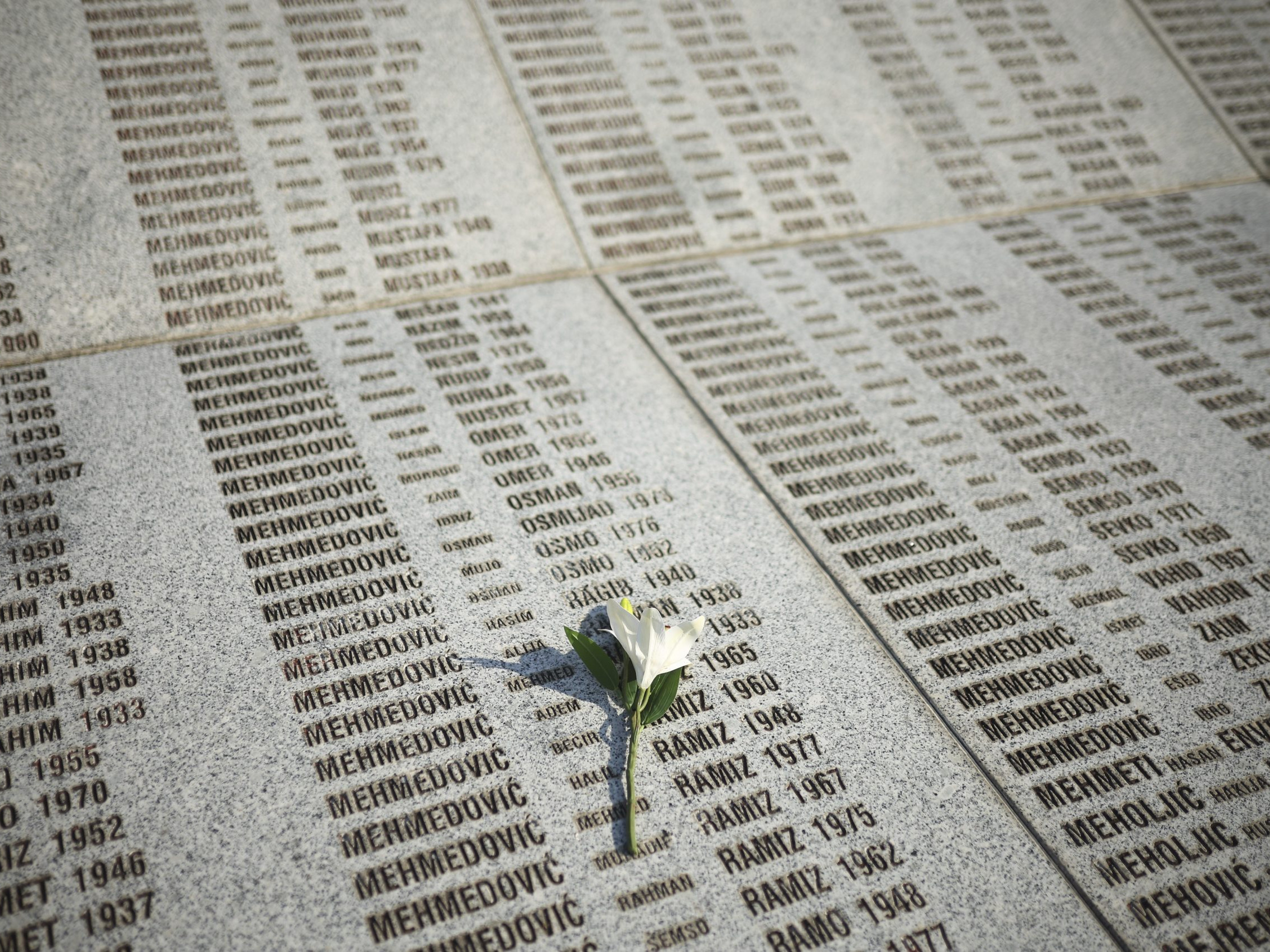 Na snímke kvet na pamätnej tabuli s menami obetí srebrenickej genocídy sa nachádza na cintoríne v obci Počotari.