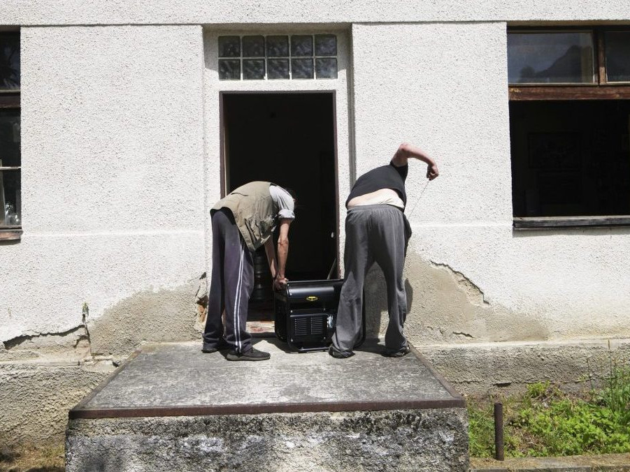 Obyvatelia sa snažia naštartovať generátor počas výpadku elektriny v Benešove pri Prahe.