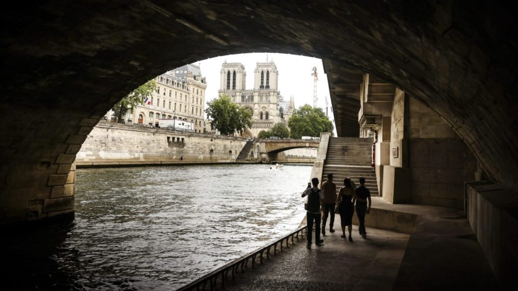 Ľudia sa prechádzajú popri rieke Seina v Paríži.