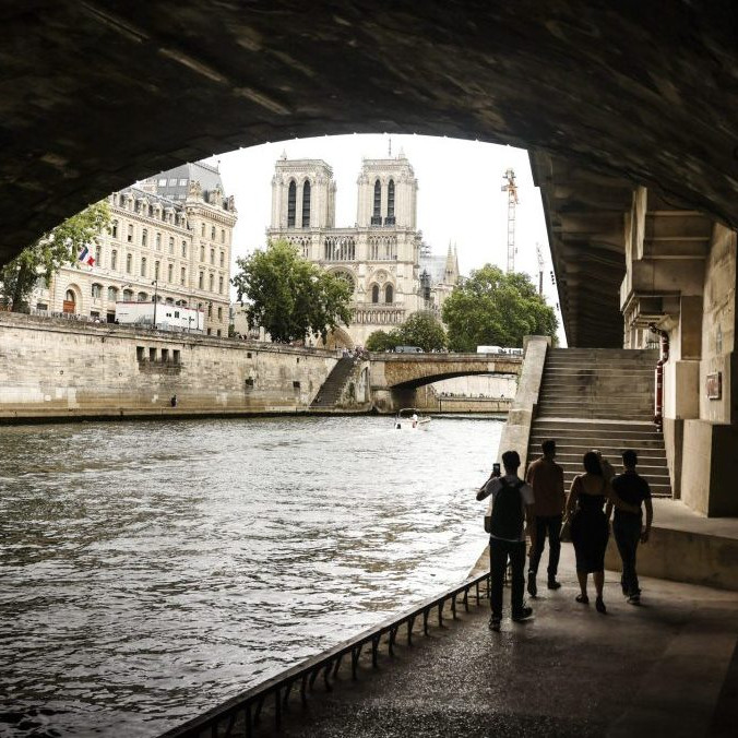 Ľudia sa prechádzajú popri rieke Seina v Paríži.