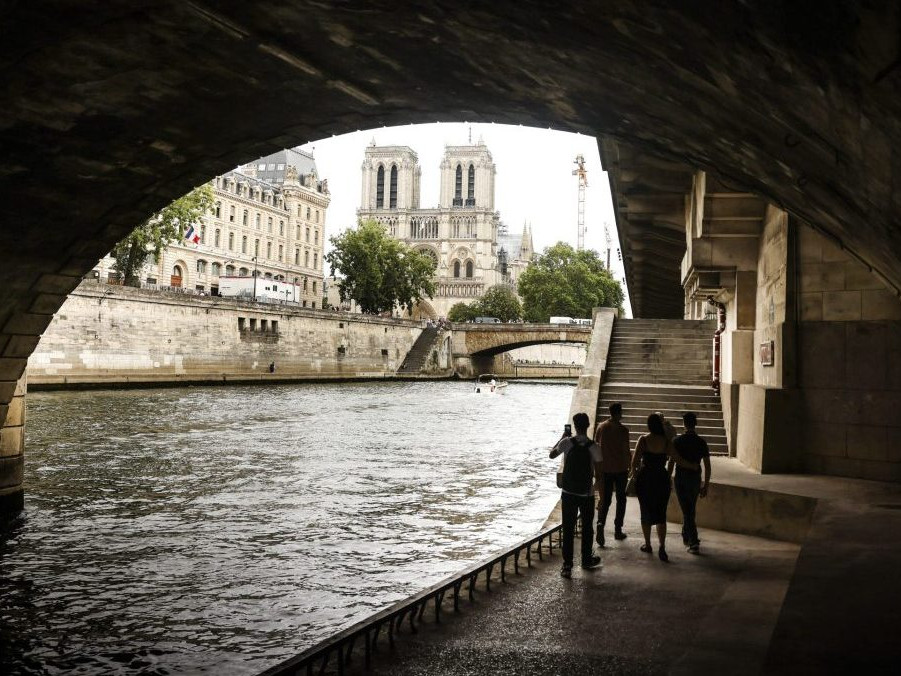 Ľudia sa prechádzajú popri rieke Seina v Paríži.