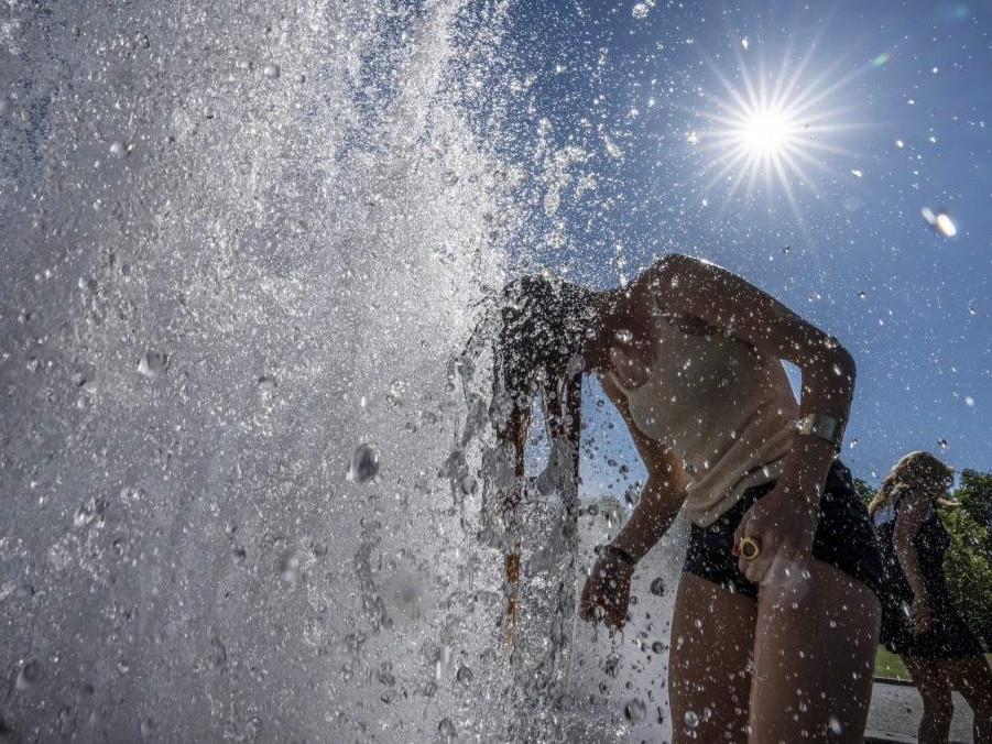 Ľudia sa osviežujú vo fontáne počas horúčav v Berlíne.