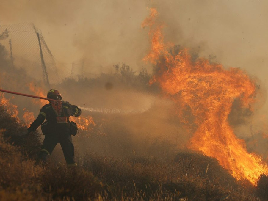 Na snímke sa hasič snaží uhasiť lesný požiar neďaleko mesta Ierapetra na južnom pobreží gréckeho ostrova Kréta.