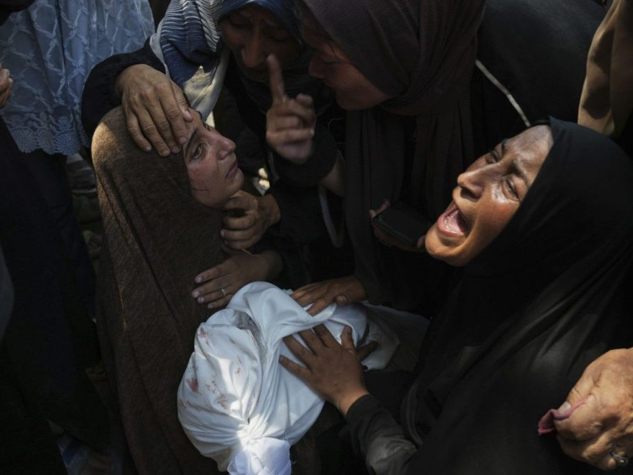 Smútiace ženy držia telo 11-ročného chlapca, ktorý zahynul pri izraelskom leteckom útoku na školu v Gaze.