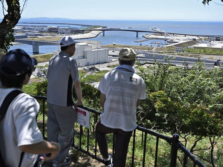 Ľudia, ktorí sa evakuovali na horu Hiyoriyama, sledujú more v Išinomaki.