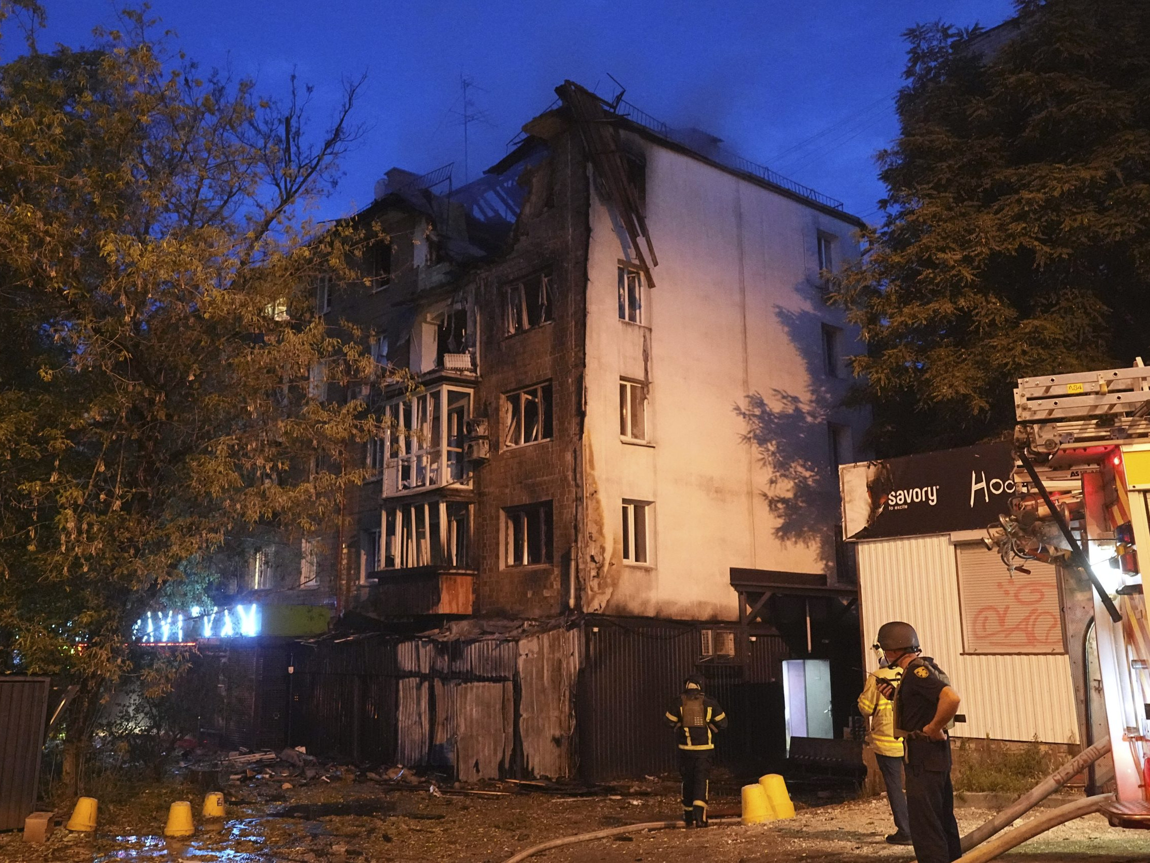 Na archívnej snímke hasiči zasahujú pred obytnou budovou po útoku ruskej armády na ukrajinskú metropolu Kyjev.