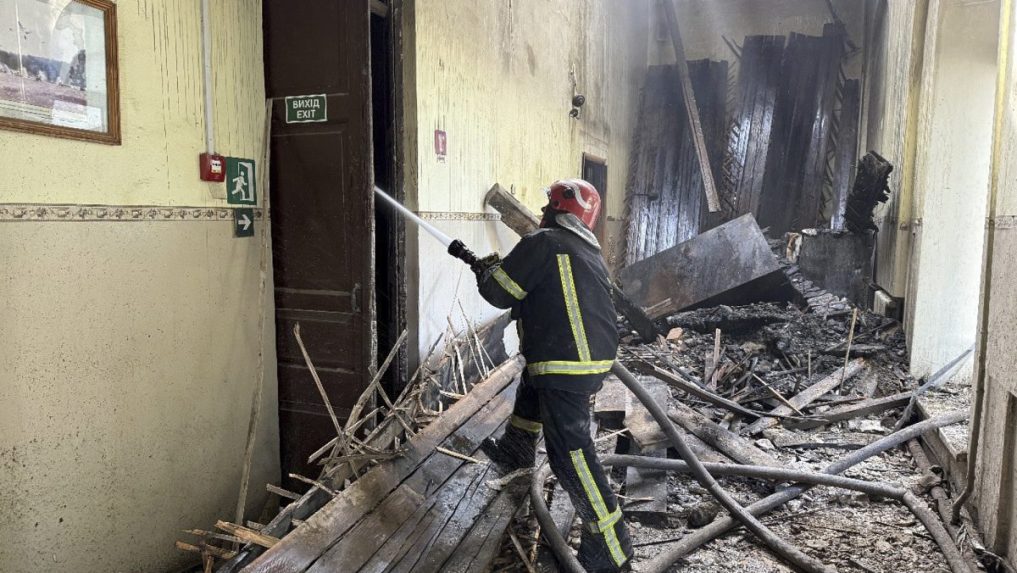 Ukrajinský hasič zasahuje pri požiari školy po ruskom útoku.
