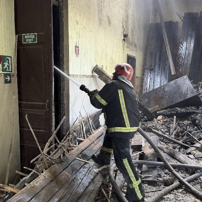 Ukrajinský hasič zasahuje pri požiari školy po ruskom útoku.