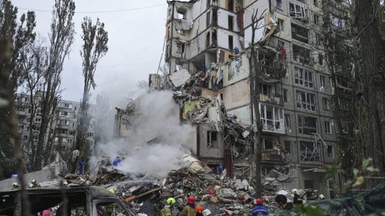 Záchranári pracujú v zničenom obytnom dome po ruskom raketovom útoku v Kyjeve.