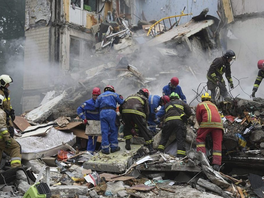 Záchranári pracujú v zničenom obytnom dome po útoku ruskou raketou v Kyjeve.