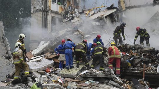 Záchranári pracujú v zničenom obytnom dome po útoku ruskou raketou v Kyjeve.