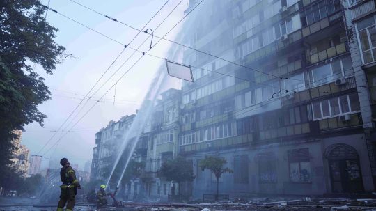 Na archívnej snímke z 10. júla 2025 príslušníci záchranných služieb sa snažia uhasiť požiar obytného domu po útokoch ruskej armády v Kyjeve.