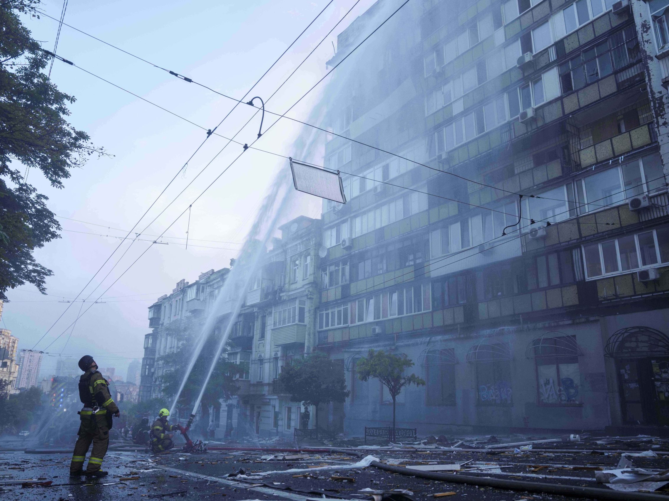 Na archívnej snímke z 10. júla 2025 príslušníci záchranných služieb sa snažia uhasiť požiar obytného domu po útokoch ruskej armády v Kyjeve.