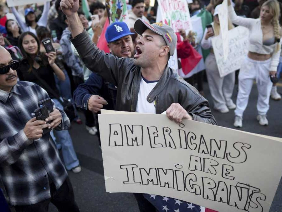 Muž s transparentom "Američania sú imigranti".