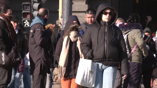 Na snímke sú ľudiach v uliciach Buenos Aires oblečený v hrubom zimnom oblečení.
