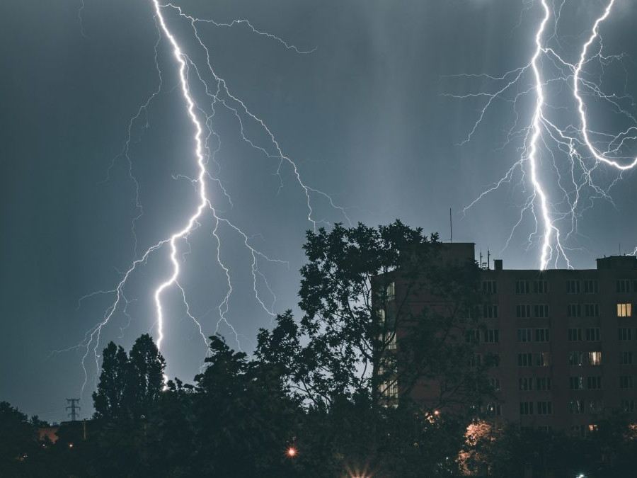 Na snímke sú blesky nad kopcami a lesom.