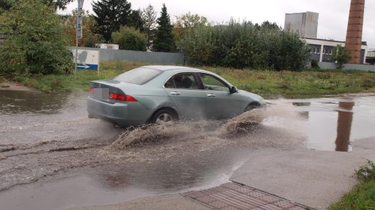 Na snímke osobné auto jazdí po zaplavenej ceste v dôsledku intenzívneho dažďa.
