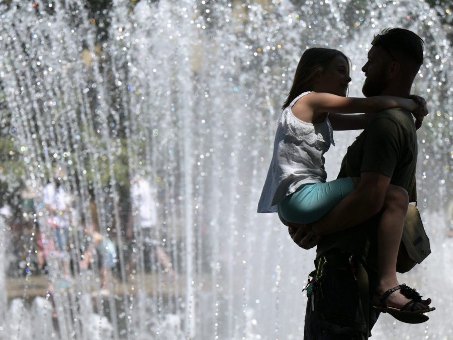 Na snímke ľudia počas horúceho letného dňa pri fontáne.