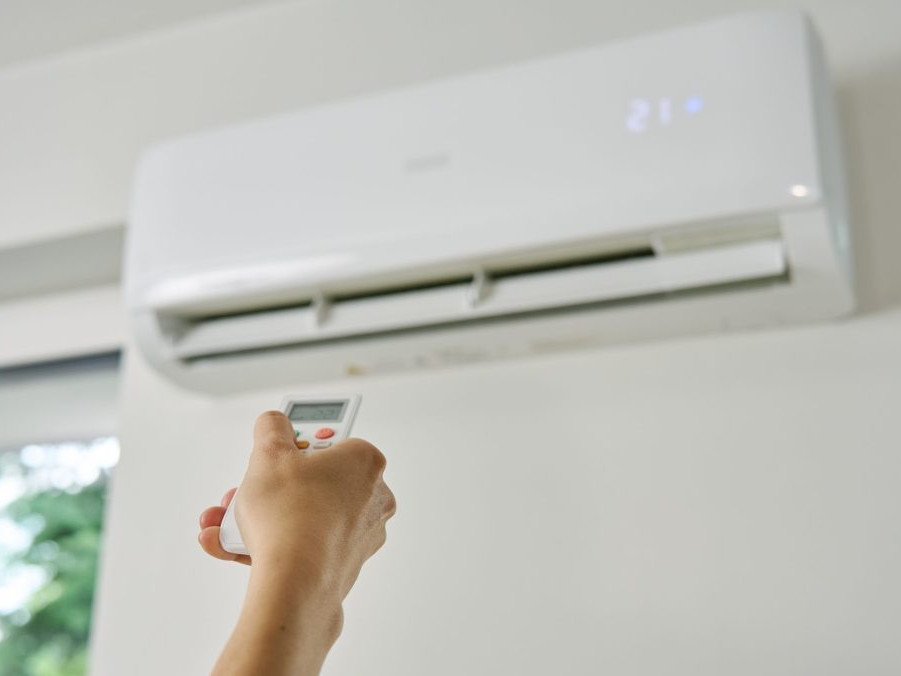 ruka stláča ovládač na klimatizáciu