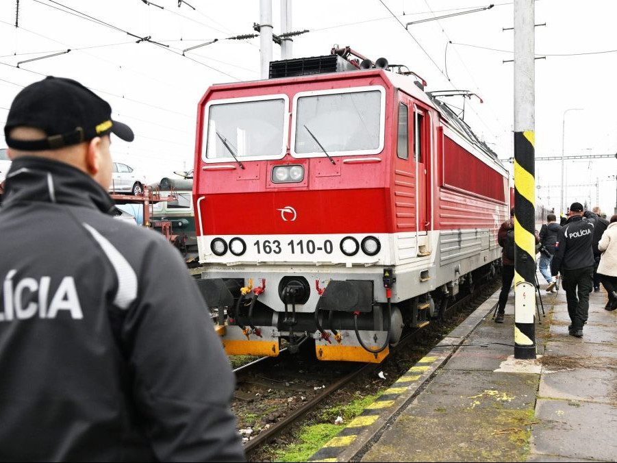 policajt stojí pred vlakom