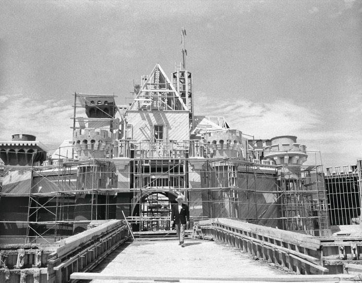 Na snÃƒÂ­mke Walt Disney prechÃƒÂ¡dza cez most pred rozostavanÃƒÂ½m vchodom do Disneylandu.