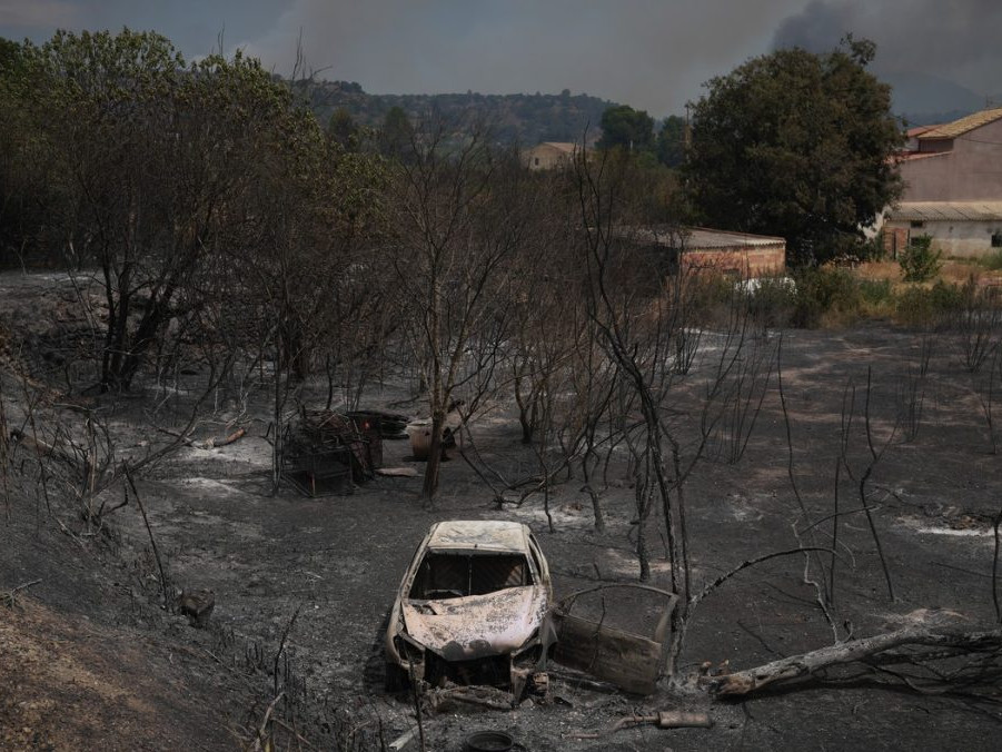 Na snímke vrak zhoreného auta a spálený porast po požiari v Katalásnku.
