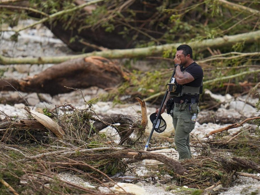 Zástupca šerifa sa zastavuje pri prečesávaní brehov rieky Guadalupe neďaleko Camp Mystic po tom, ako sa oblasťou prehnala blesková povodeň.