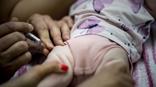Na archívnej snímke zo 7. júna 2021 v Berlíne pediatrička podáva dojčaťu kombinovanú vakcínu na základné očkovanie.