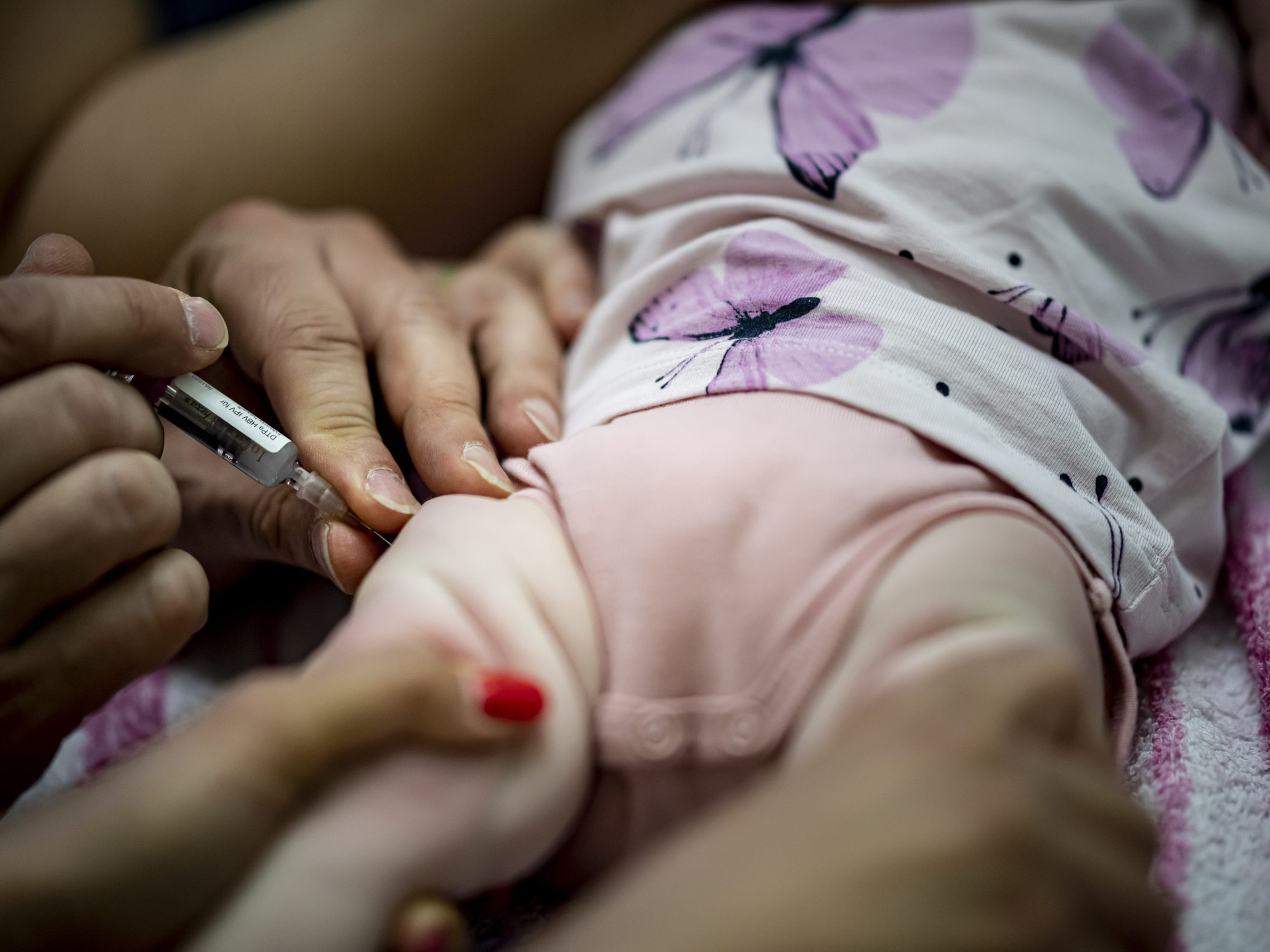 Na archívnej snímke zo 7. júna 2021 v Berlíne pediatrička podáva dojčaťu kombinovanú vakcínu na základné očkovanie.