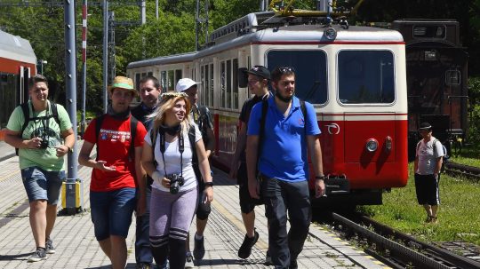 Na snímke turisti na peróne na železničnej stanici, za nimi vlak.