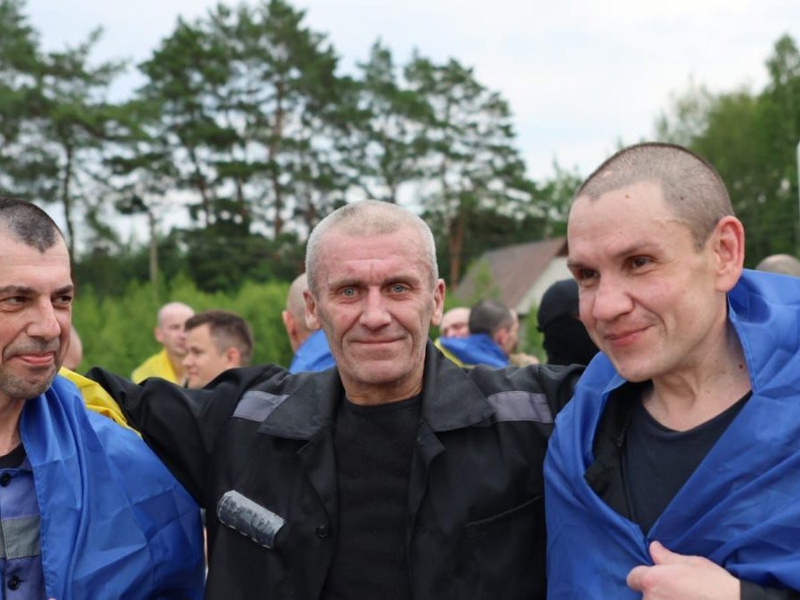 Fotografia prepustených vojakov zavinutých v ukrajinskej vlajke.