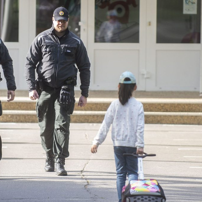 Na snímke policajti a žiačka základnej školy.