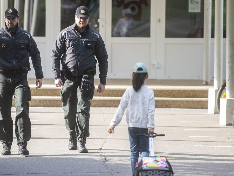 Na snímke policajti a žiačka základnej školy.