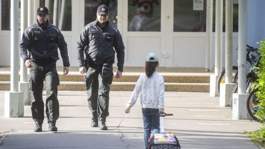 Na snímke policajti a žiačka základnej školy.