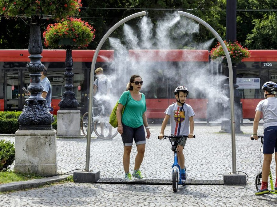 Ľudia sa ochladzujú v stojanoch s vodnou hmlou.