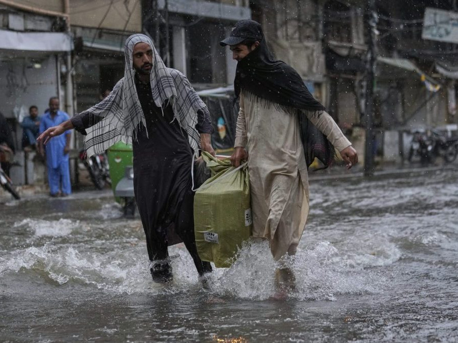 Muži počas monzúnových dažďov v Pakistane.