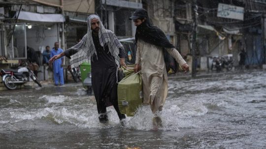 Muži počas monzúnových dažďov v Pakistane.