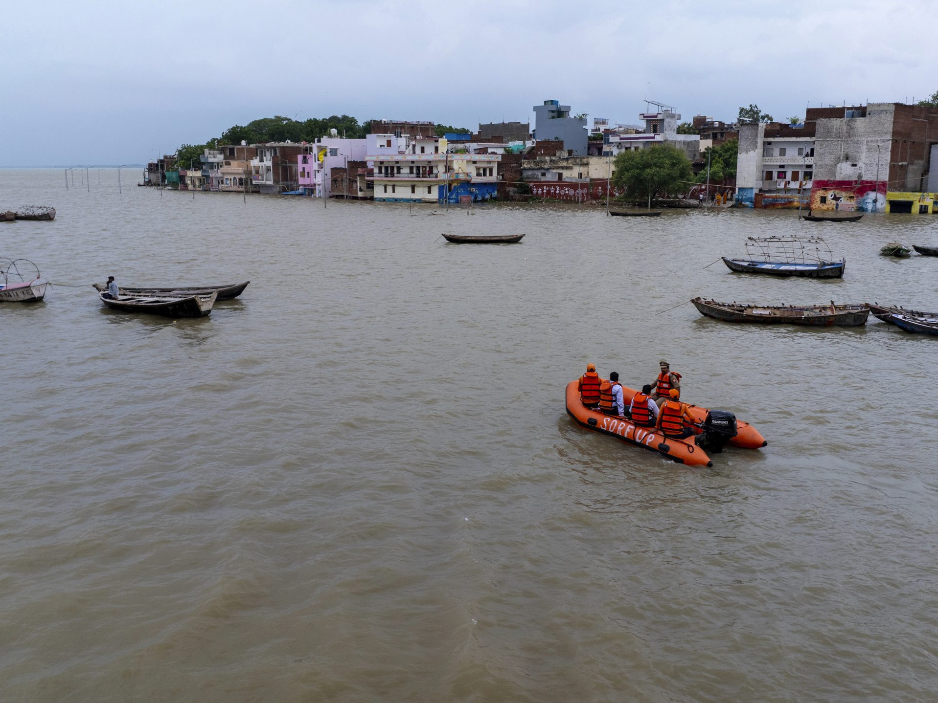 Na snímke príslušníci záchranných zložiek pomáhajú v zaplavenej oblasti v meste Prajágrádž v Indii.