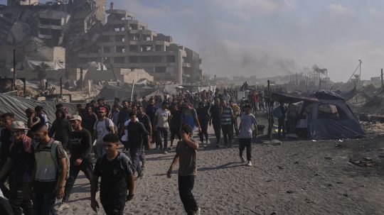 Palestínčania kráčajú po ceste smerom k oblasti na severe Pásma Gazy, kam vchádzajú nákladné autá s humanitárnou pomocou v meste Gaza.