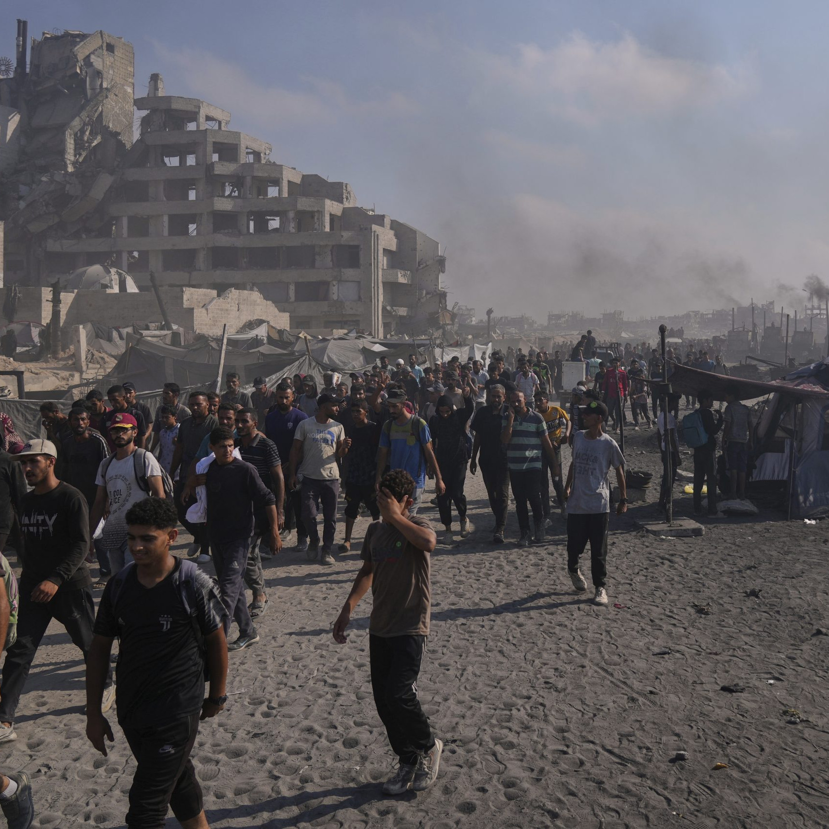 Palestínčania kráčajú po ceste smerom k oblasti na severe Pásma Gazy, kam vchádzajú nákladné autá s humanitárnou pomocou v meste Gaza.