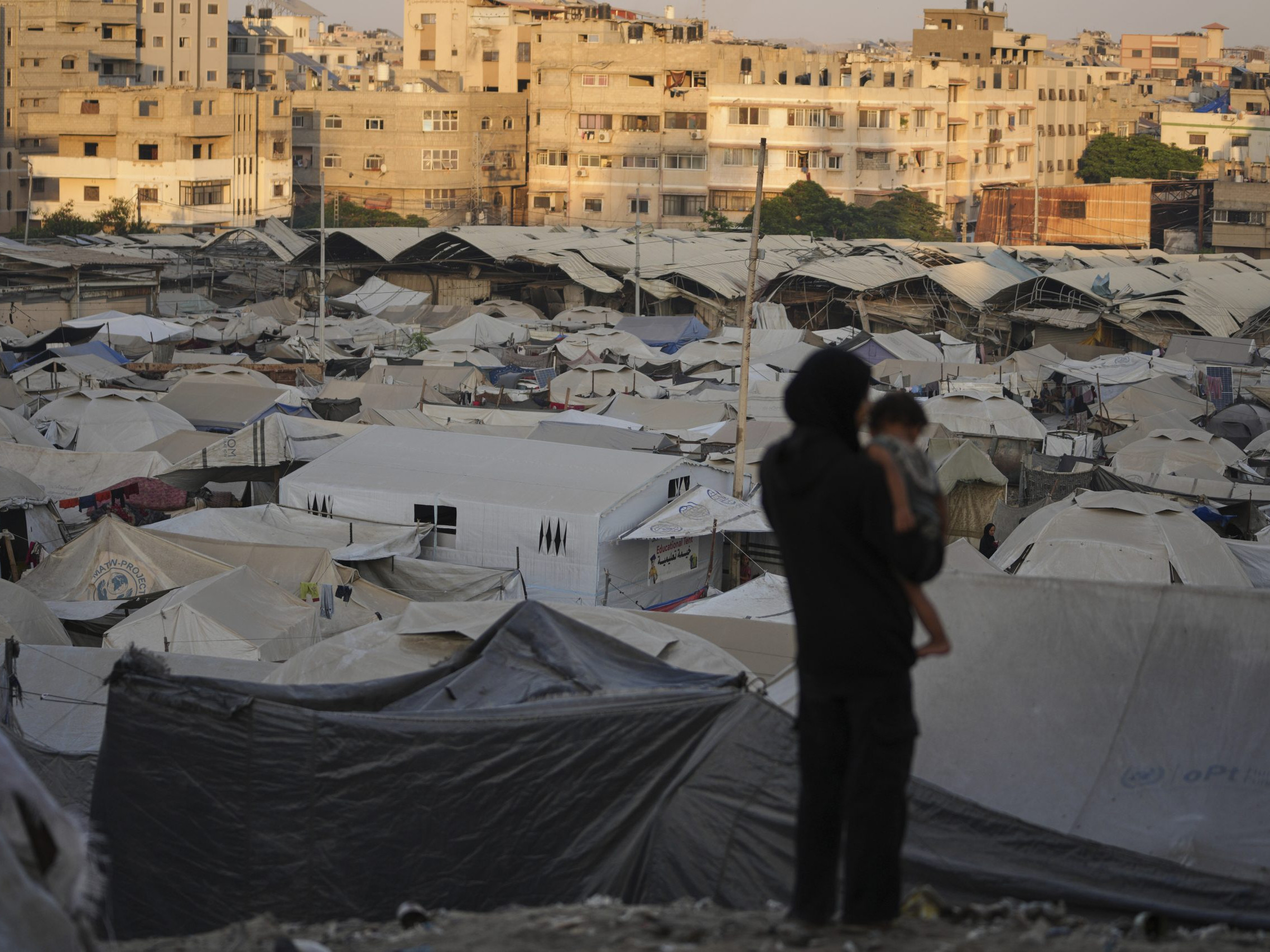 Na snímke Palestínčanka drží v náručí dieťa v stanovom tábore pre vysídlených Palestínčanov v meste Gaza.