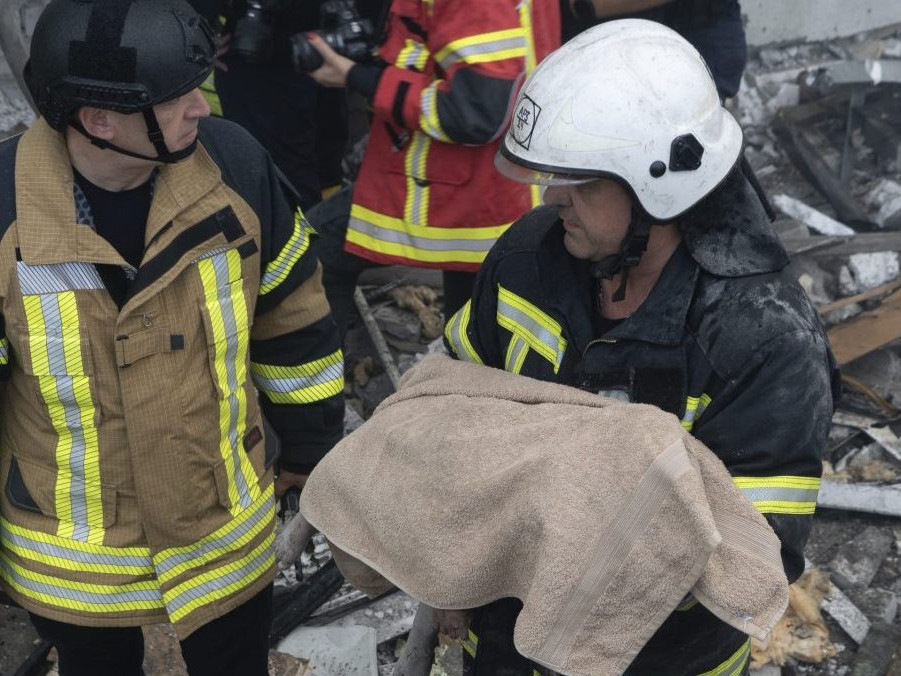 Na snímke záchranár odnáša telo dieťaťa, ktoré prišlo o život pri raketovom útoku ruskej armády na obytnú budovu v ukrajinskom meste Charkov.