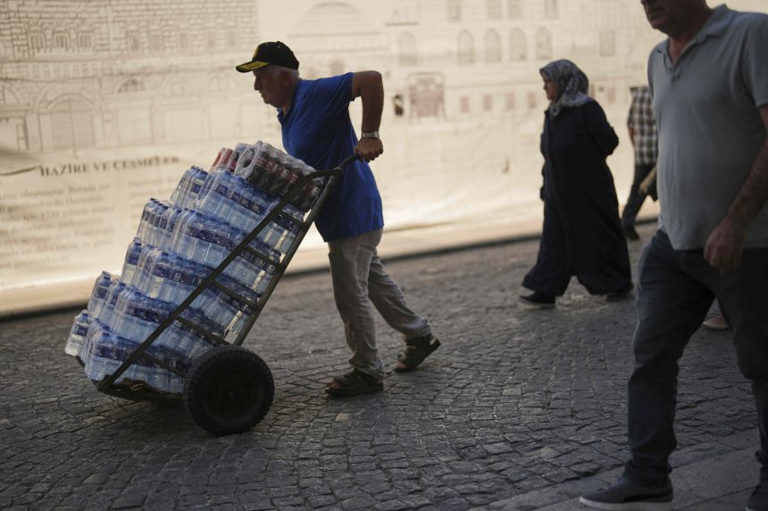 Na snímke muž nesie plastové fľaše s vodou počas horúceho letného dňa v tureckom Istanbul.